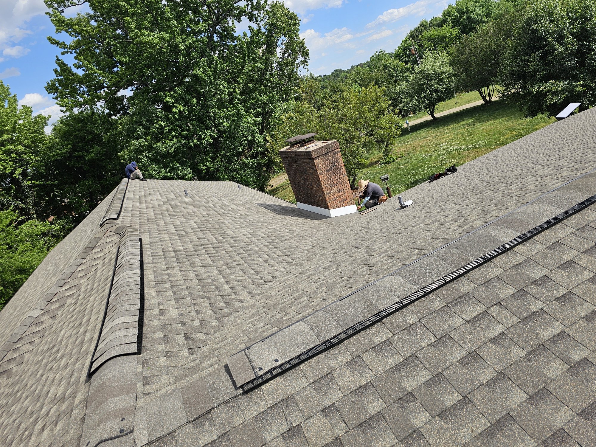 Clean chimney and shingle detail on a finished D&S roofing project